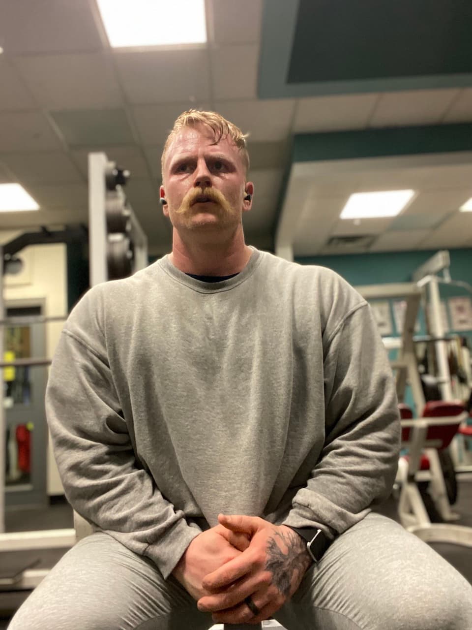 personal trainer sitting on bench facing camera